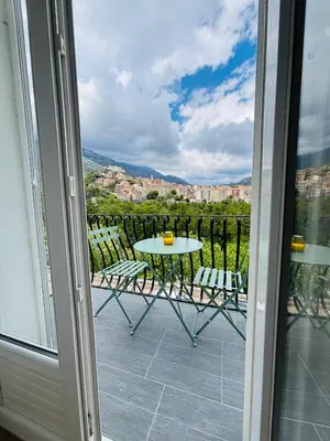 a patio with a table and chairs on a balcony at Straboni corte in Corte