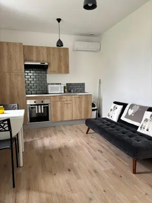 a living room with a black couch and a kitchen at Straboni corte in Corte