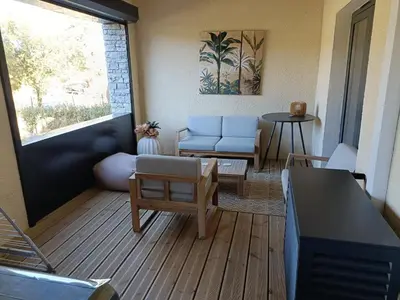 a living room with a couch and a table at Appt neuf 2-4 pers avec loggia - Piscine chauffée - Bord de mer - Corse du Sud- Bonifacio in Pianottoli-Caldarello