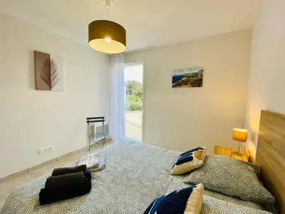 a bedroom with a large bed and a large window at BONIFACIO Villa U ARANCIU in Bonifacio