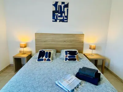 a bedroom with a bed with blue sheets and pillows at BONIFACIO Villa U ARANCIU in Bonifacio