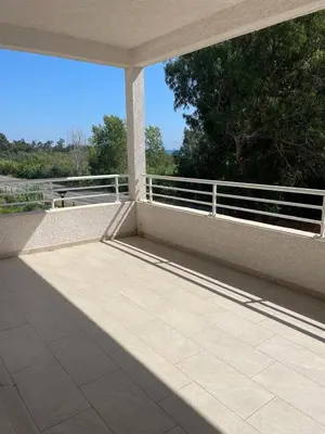 an empty patio with a white railing and trees at Appartement Solaro, plage à 100m in Solaro