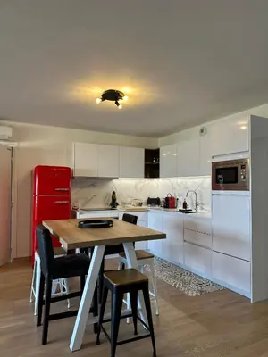 a kitchen with a wooden table and a red refrigerator at Torriciola location Genovese in Ajaccio