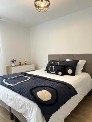 a bed with a black and white blanket on it at Torriciola location Genovese in Ajaccio