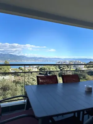 a table and chairs in front of a large window at Torriciola location Genovese in Ajaccio