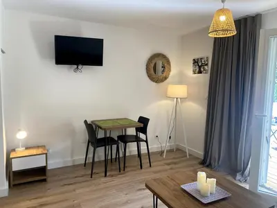 a living room with a table and chairs and a television at Studio Corse entre mer et maquis cala rossa in Lecci