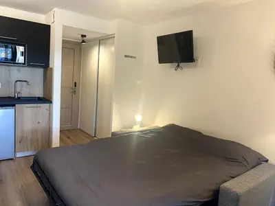 a bedroom with a bed and a television on the wall at Studio Corse entre mer et maquis cala rossa in Lecci