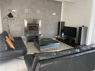 a living room with a leather couch and a fireplace at Villa Jessy Porto-Vecchio in Porto-Vecchio
