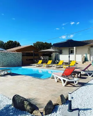 a swimming pool with lounge chairs and umbrellas at Villa Jessy Porto-Vecchio in Porto-Vecchio