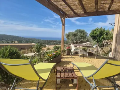 a patio with chairs and a table with a view at Vos vacances à 3 minutes de la mer in Belgodère