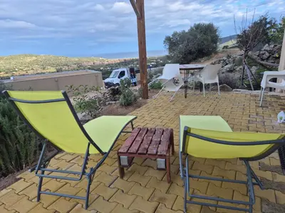 a group of chairs and a table on a patio at Vos vacances à 3 minutes de la mer in Belgodère