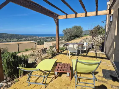 a patio with chairs and a table with a view at Vos vacances à 3 minutes de la mer in Belgodère