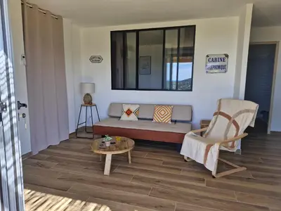 a living room with a couch and a table at Vos vacances à 3 minutes de la mer in Belgodère