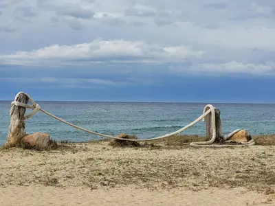a rope barrier on a beach near the ocean at Vos vacances à 3 minutes de la mer in Belgodère