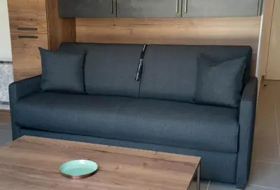 a couch in a living room with a table at Studio moderne et lumineux, proche centre ville in Propriano