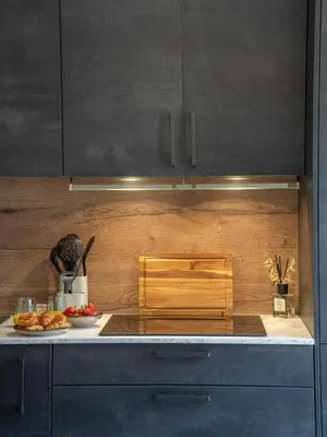 a kitchen with black cabinets and a plate of food at Studio moderne et lumineux, proche centre ville in Propriano