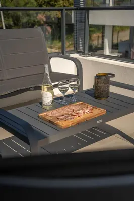a table with a cutting board and two glasses of wine at Studio moderne et lumineux, proche centre ville in Propriano
