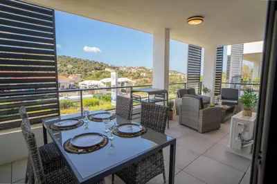 a dining room with a table and chairs on a balcony at Charmant T2 proche centre ville et terrasse in Propriano