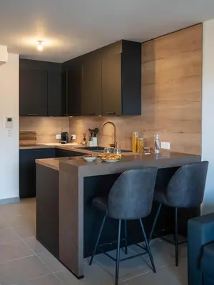 a kitchen with a large island with two bar stools at Charmant T2 proche centre ville et terrasse in Propriano