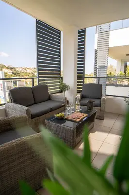 a living room with couches and a table on a balcony at Charmant T2 proche centre ville et terrasse in Propriano