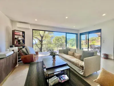 a living room with a couch and a table at Villa d'architecte avec vue mer imprenable et piscine chauffée in Viggianello