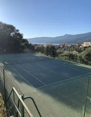 a tennis court on top of a fence at Appart résidence avec piscine in Propriano