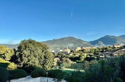 a view of a city with mountains in the background at Appart résidence avec piscine in Propriano