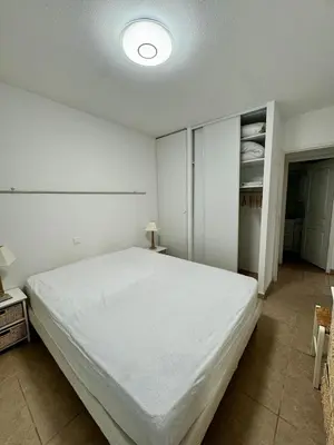 a white bedroom with a large bed in it at Appart résidence avec piscine in Propriano