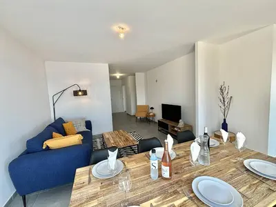 a living room with a table and a blue couch at Appartement Cargèse Théâtre de Verdure in Cargèse