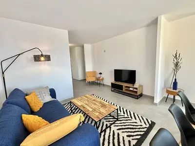 a living room with a blue couch and a tv at Appartement Cargèse Théâtre de Verdure in Cargèse