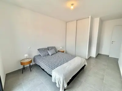 a bedroom with a bed and a side table at Appartement Cargèse Théâtre de Verdure in Cargèse