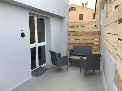 a patio with two chairs and a table on a building at Saleccia in Santa-Lucia-di-Moriani