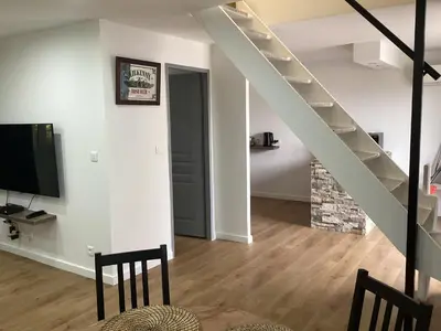 a living room with a staircase and a television at Saleccia in Santa-Lucia-di-Moriani
