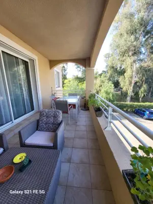 a patio with a table and a couch on a balcony at T3 Vue mer bord de mer in Albitreccia