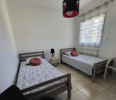 two twin beds in a room with a window at T3 Vue mer bord de mer in Albitreccia