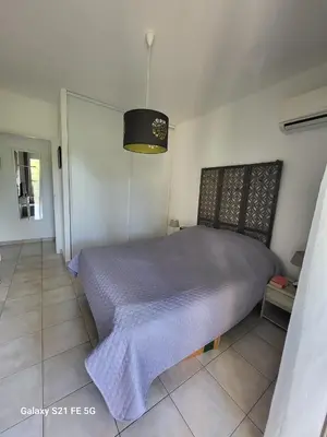 a bedroom with a bed with a purple blanket at T3 Vue mer bord de mer in Albitreccia