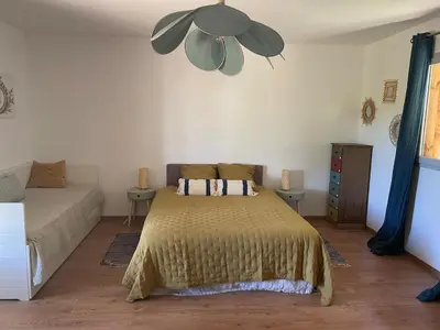 a bedroom with a bed and a ceiling fan at Jolie maison familiale au cœur des vignes in Sartène