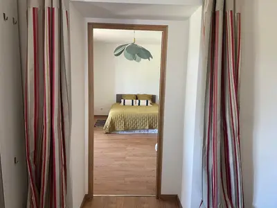 a room with a bedroom with a bed and a mirror at Jolie maison familiale au cœur des vignes in Sartène