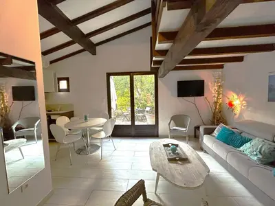 a living room with a couch and a table at Mini-villa à 1 minute de la plage de Santa Giulia in Porto-Vecchio