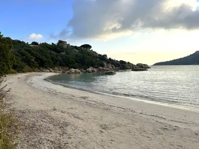 a sandy beach with rocks in the water at Mini-villa à 1 minute de la plage de Santa Giulia in Porto-Vecchio