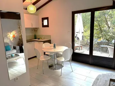 a kitchen and dining room with a table and chairs at Mini-villa à 1 minute de la plage de Santa Giulia in Porto-Vecchio