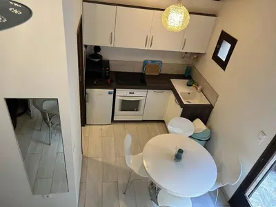 a small kitchen with a white table and chairs at Mini-villa à 1 minute de la plage de Santa Giulia in Porto-Vecchio