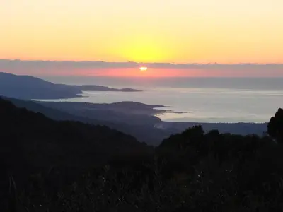 a view of the sun setting over the ocean at Gîtes ruraux Aria Falcona in Santa-Maria-Figaniella