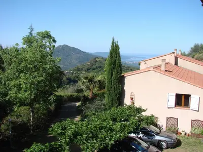 a view of a house with trees and cars at Gîtes ruraux Aria Falcona in Santa-Maria-Figaniella