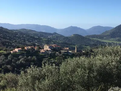 a village in a valley with mountains in the background at Gîtes ruraux Aria Falcona in Santa-Maria-Figaniella