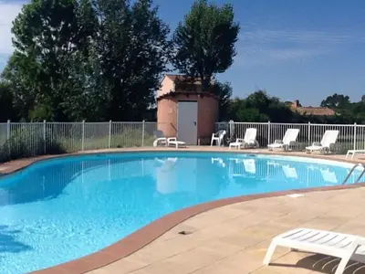 a large blue swimming pool with chairs and a fence at Mini villa a 300m de la plage in Zonza