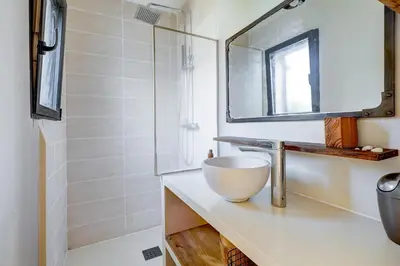 a bathroom with a sink and a mirror at A Stalla - Maison pieds dans l'eau à Lucciana in Lucciana