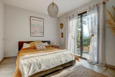 a bedroom with a bed and a large window at A Stalla - Maison pieds dans l'eau à Lucciana in Lucciana