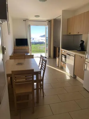 a kitchen with a table and a kitchen with a view at 4-6 couchages vue mer et port de Solenzara Corse in Sari Solenzara
