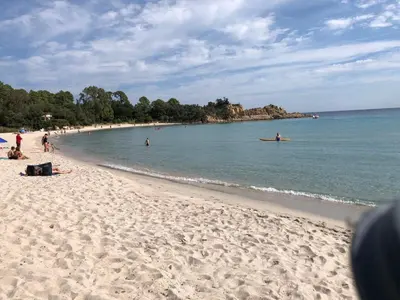 a beach with a group of people in the water at 4-6 couchages vue mer et port de Solenzara Corse in Sari Solenzara